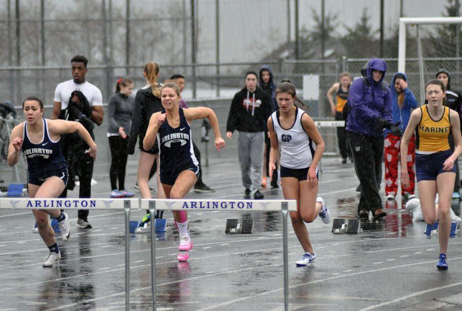 Female athletes compete in a hurdles competition.