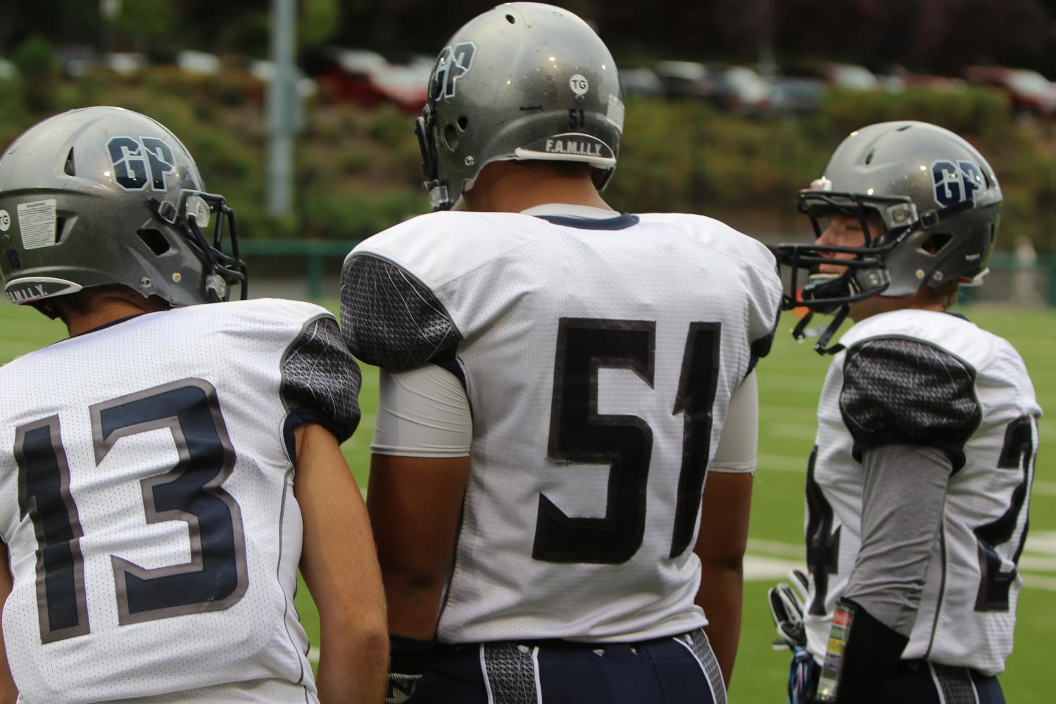 A football player stands at the sidelines during a practice.