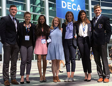 The group takes a picture in front of the conference center.