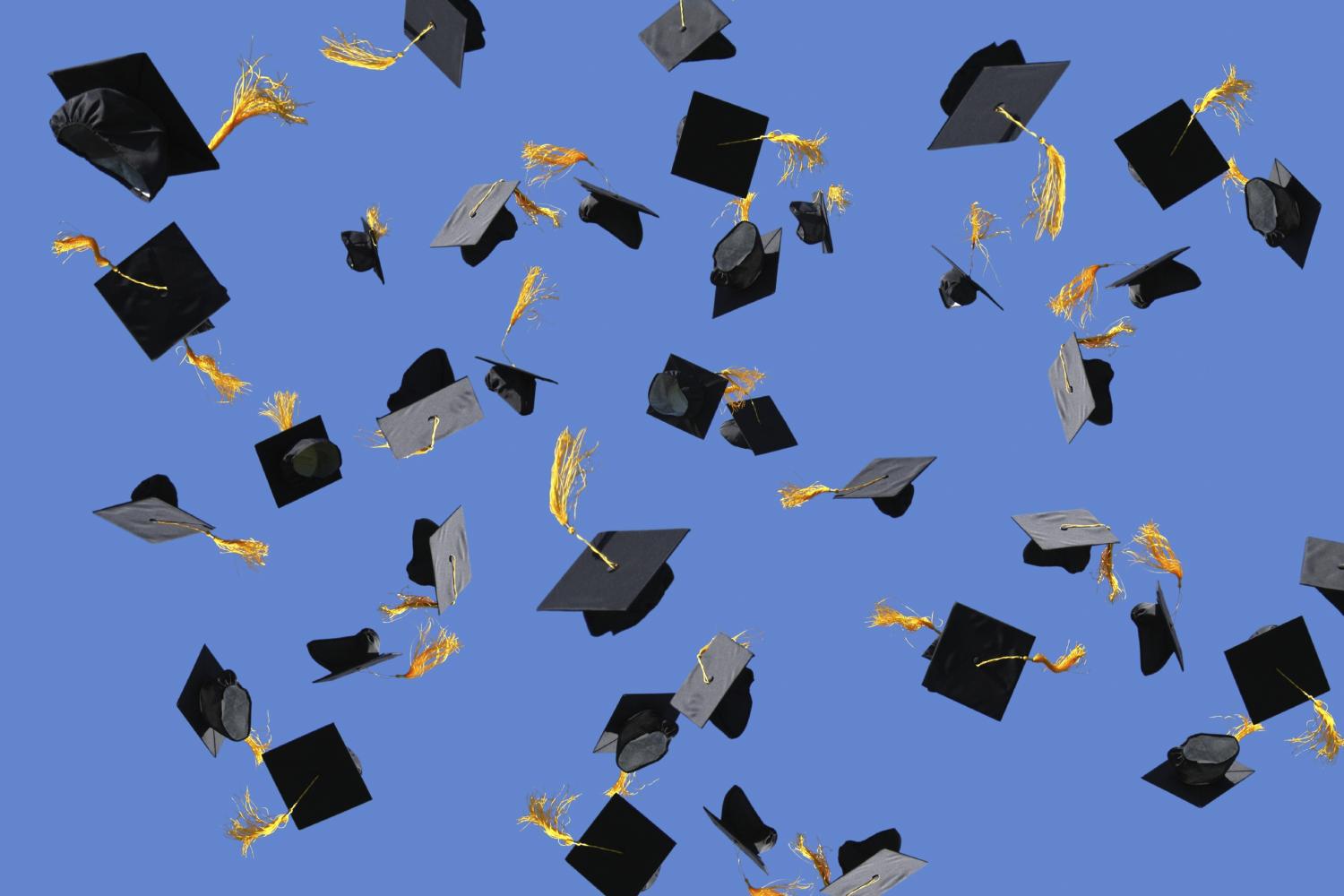 Graduation caps being thrown through the air.