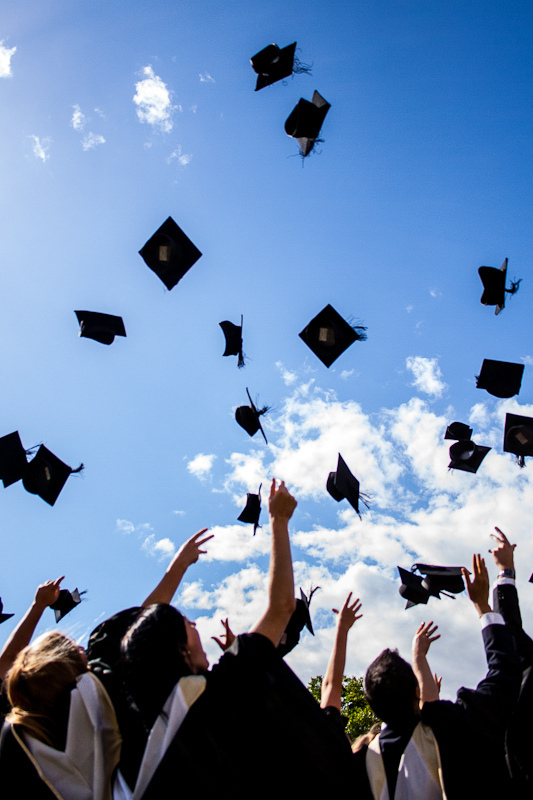 Seniors go on their way, throwing their caps in the air in celebration.