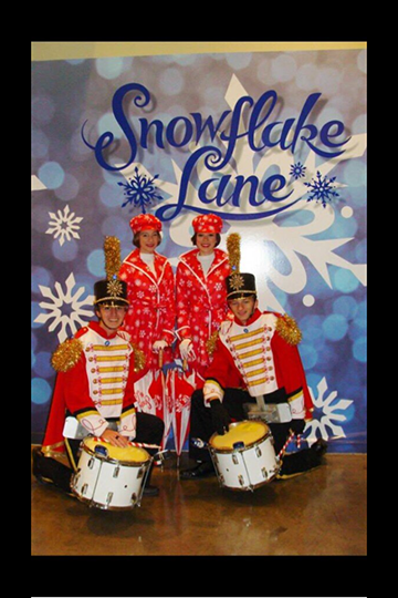 Five members of Snowflake Lane members in front of a poster. 