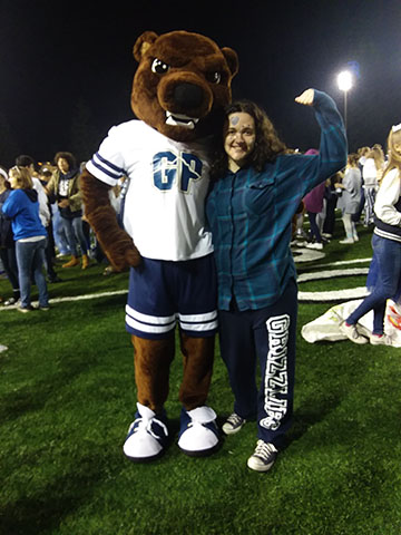 Student poses with the mascot at the homecoming game.