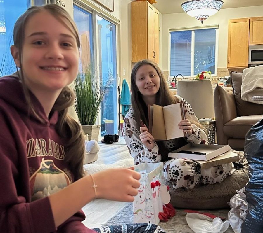 Helena Simpkins (right) and her sister Emma (left) open gifts on Christmas morning.